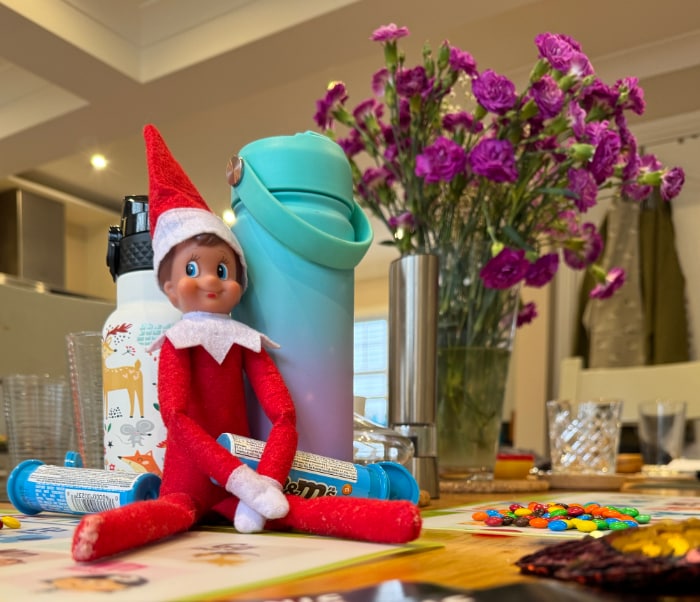 the house let leaning against a blue water bottle on the table