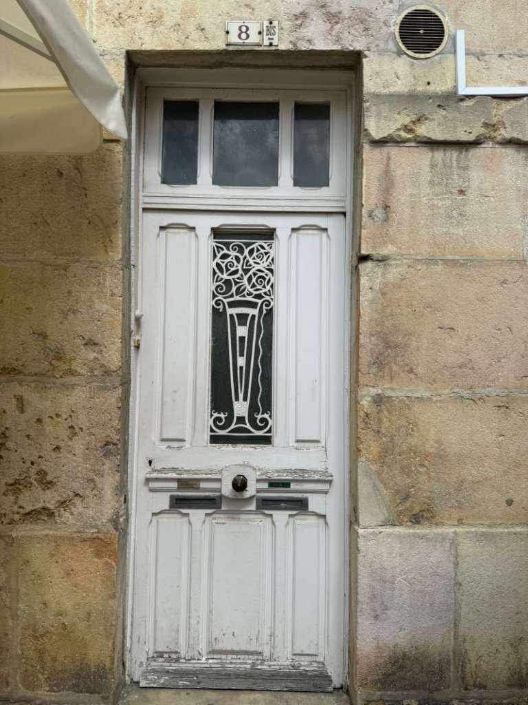 an old but very ornate door painted white and in much need of repair
