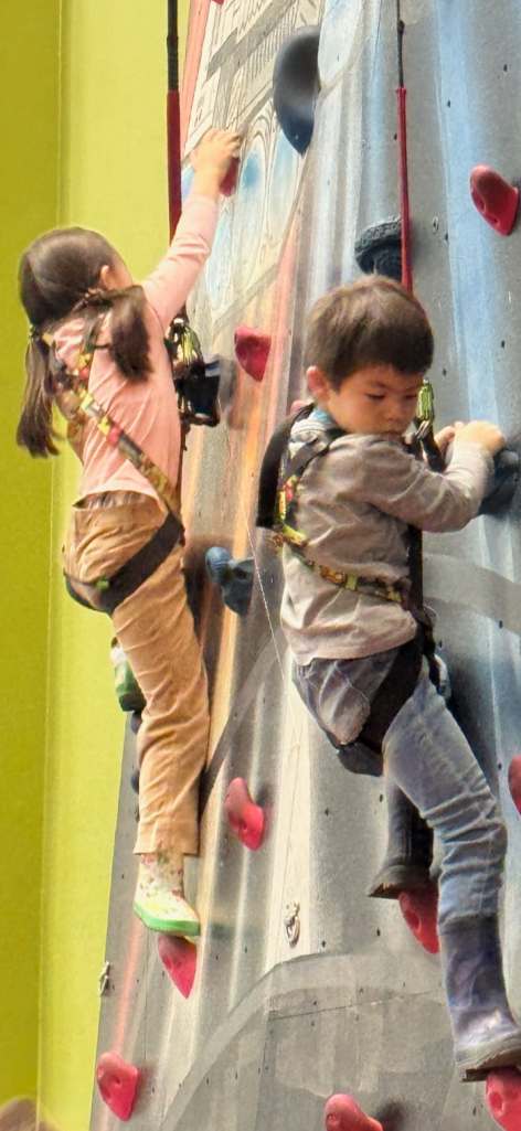 boy and girl unharnesses on climbing wall