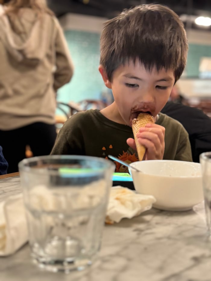 a boy eating chocolate ice cream cone.