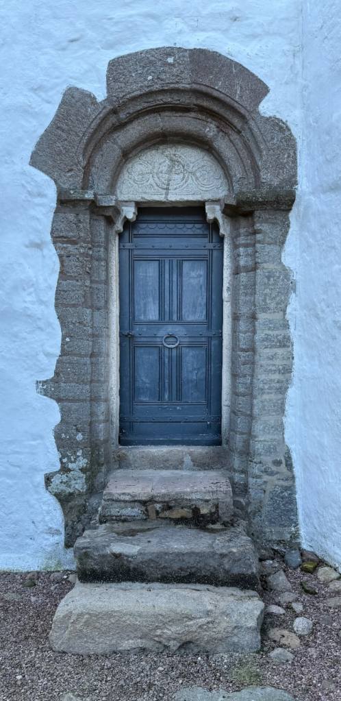 11th century church on Bornholm with stone surround, and a spell carved into the stone header wishing women fertility.