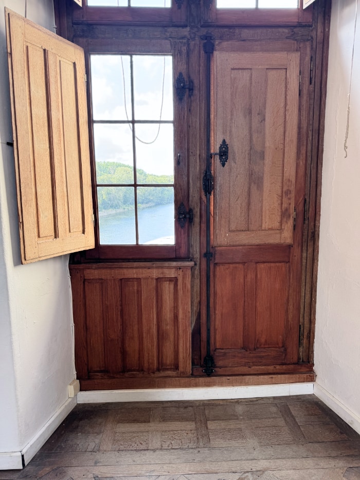 a door leading to the River Cher, Château de Chenonceau, France. Double door, each wide with a window.