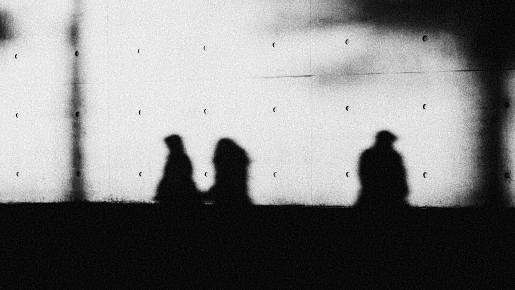 b/w image of people in silhouette on a wall