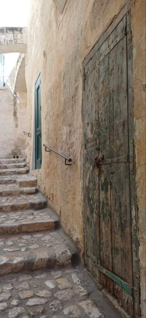 Photo taken by Spira at At Matera, Italy, of alleyway, stone walkway, and old wooden door