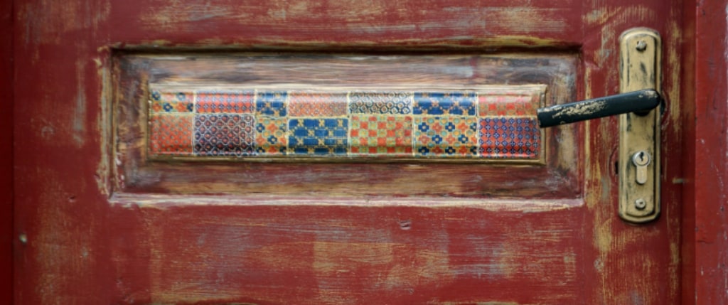 wooden door with a ceramic panel and brass knob